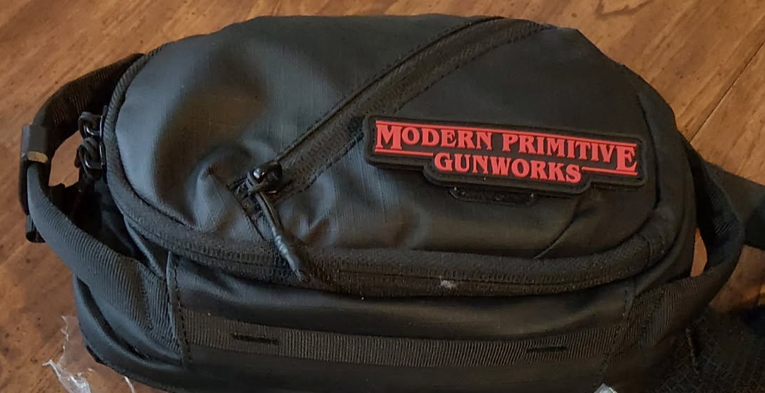 Modern Primitive Gunworks PVC logo patch attached to a black gear bag
